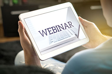Person holding tablet viewing a webinar